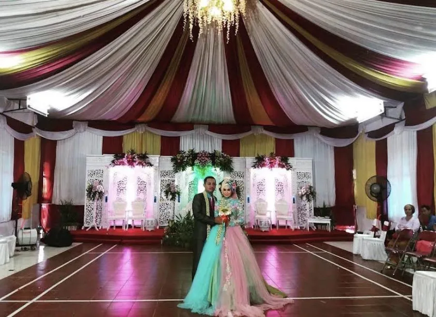Sepasang pengantin di panggung pernikahan hasil tata rias Ellya Wedding Organizer